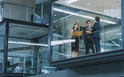 office building exterior looking through window chinese business person meeting working late at night in meeting room
