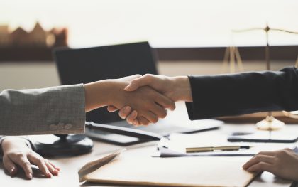Businessman shaking hands to seal a deal with his partner lawyers or attorneys discussing a contract agreement