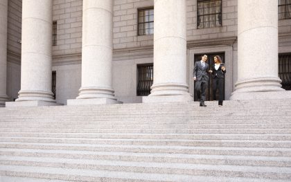 Lawyer and Client Descend Courthouse Staircase