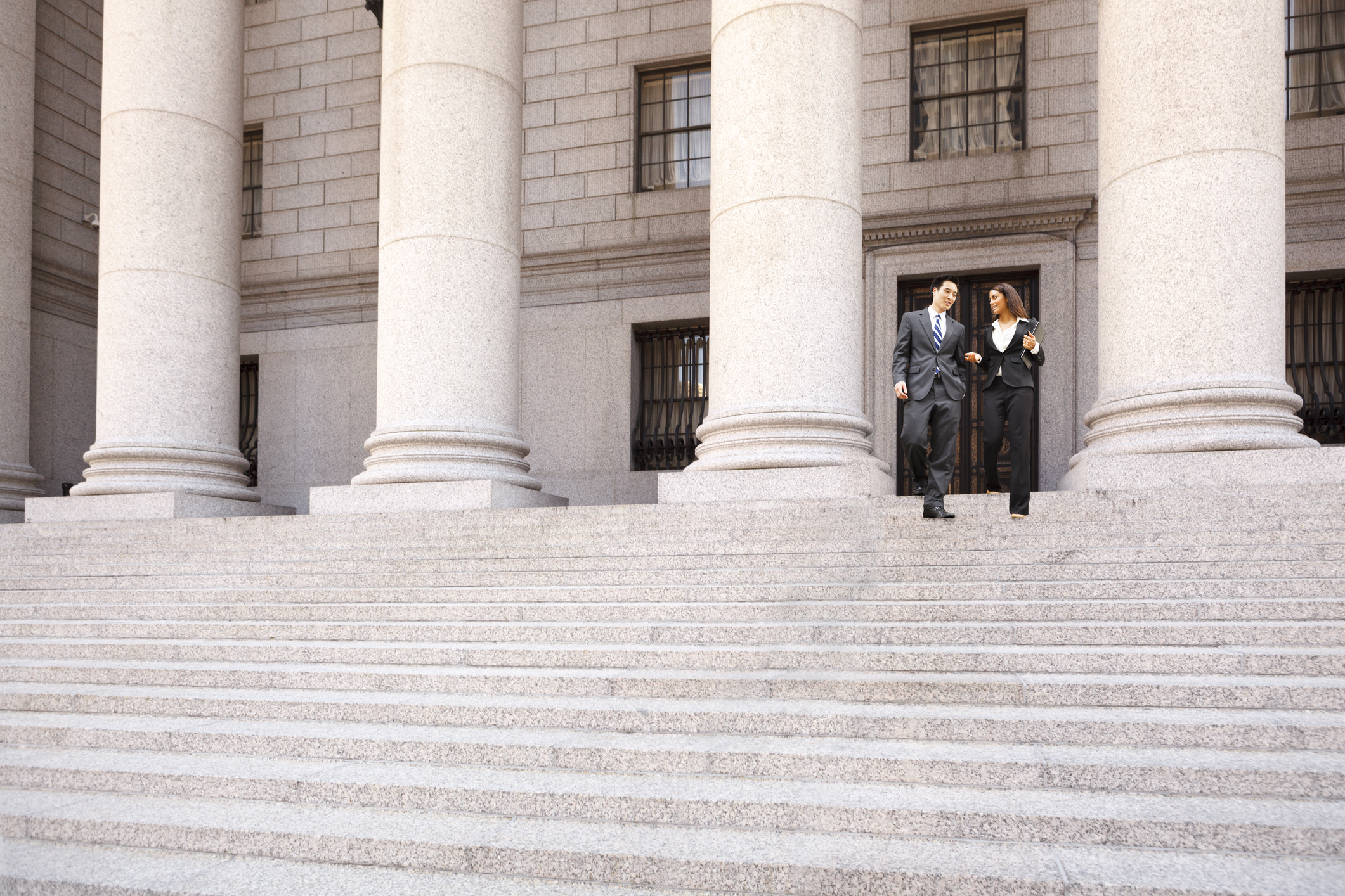 Lawyer and Client Descend Courthouse Staircase