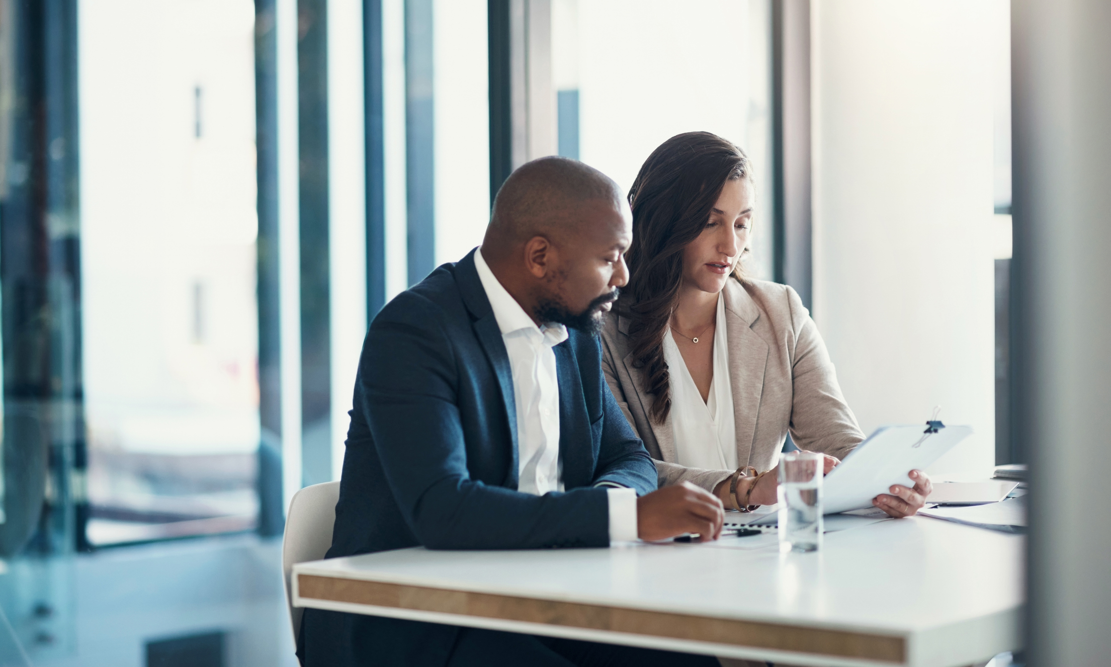 Office, woman and man with contract, consulting and financial advice for business plan or audit report. Accounting, finance and businessman with tax advisor checking paperwork for review or feedback.